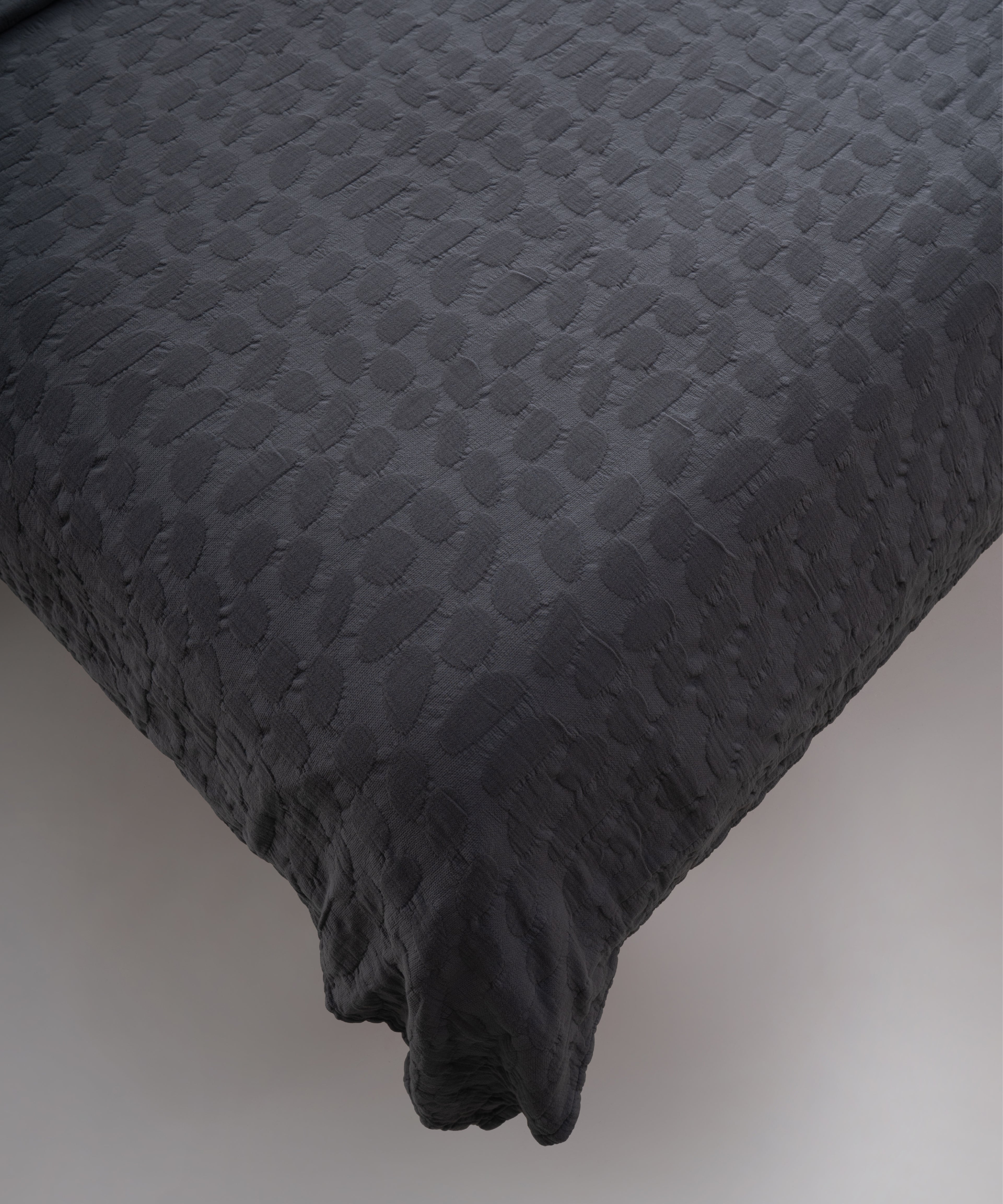 Castle Rock renkli stonewash %100 pamuk yatak örtüsü kumaşının yumuşak ve doğal dokusu, yakın plan