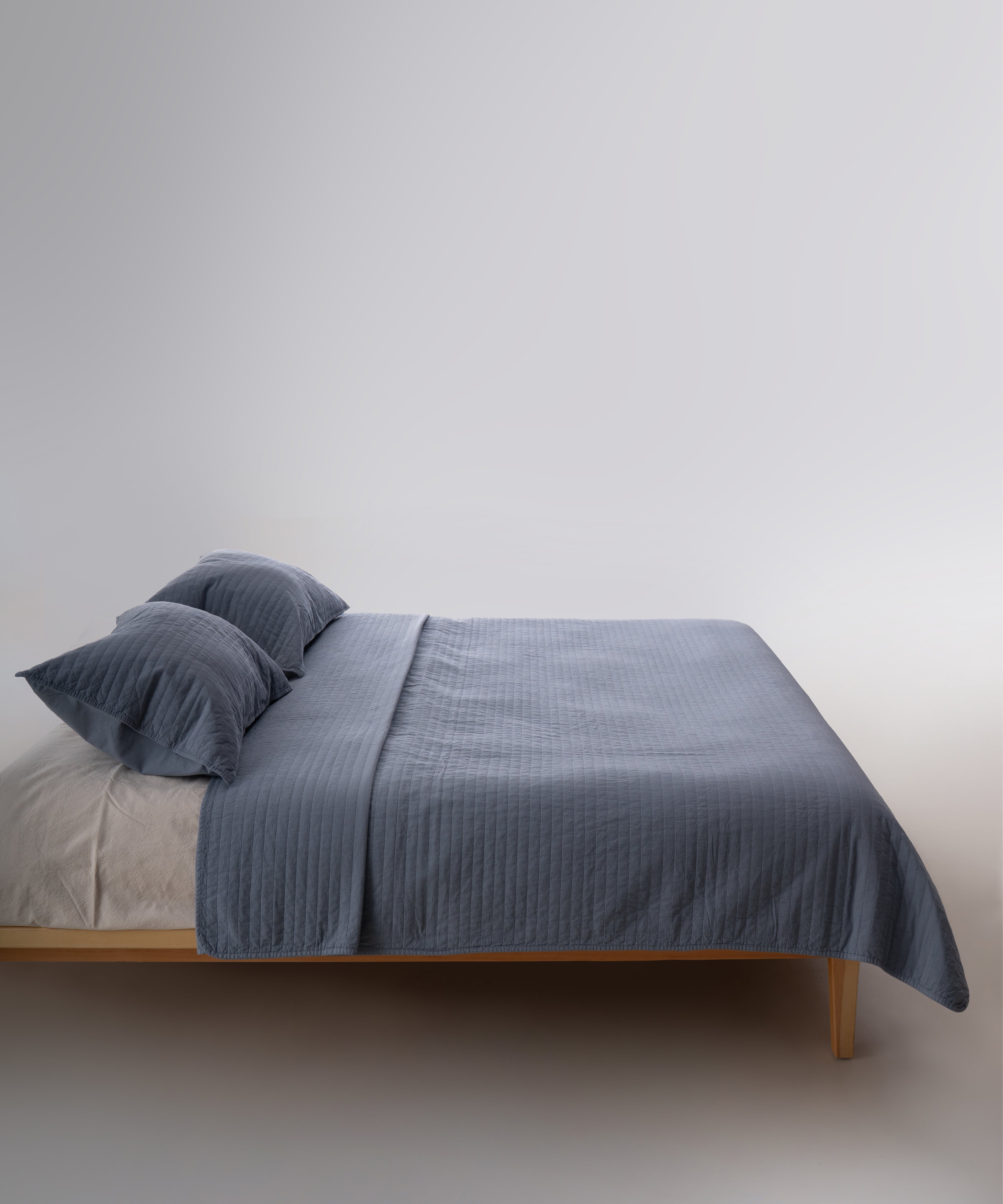 Akdeniz mavisi stonewash %100 pamuk yatak örtüsü kumaşının yumuşak ve doğal dokusu, yakın plan