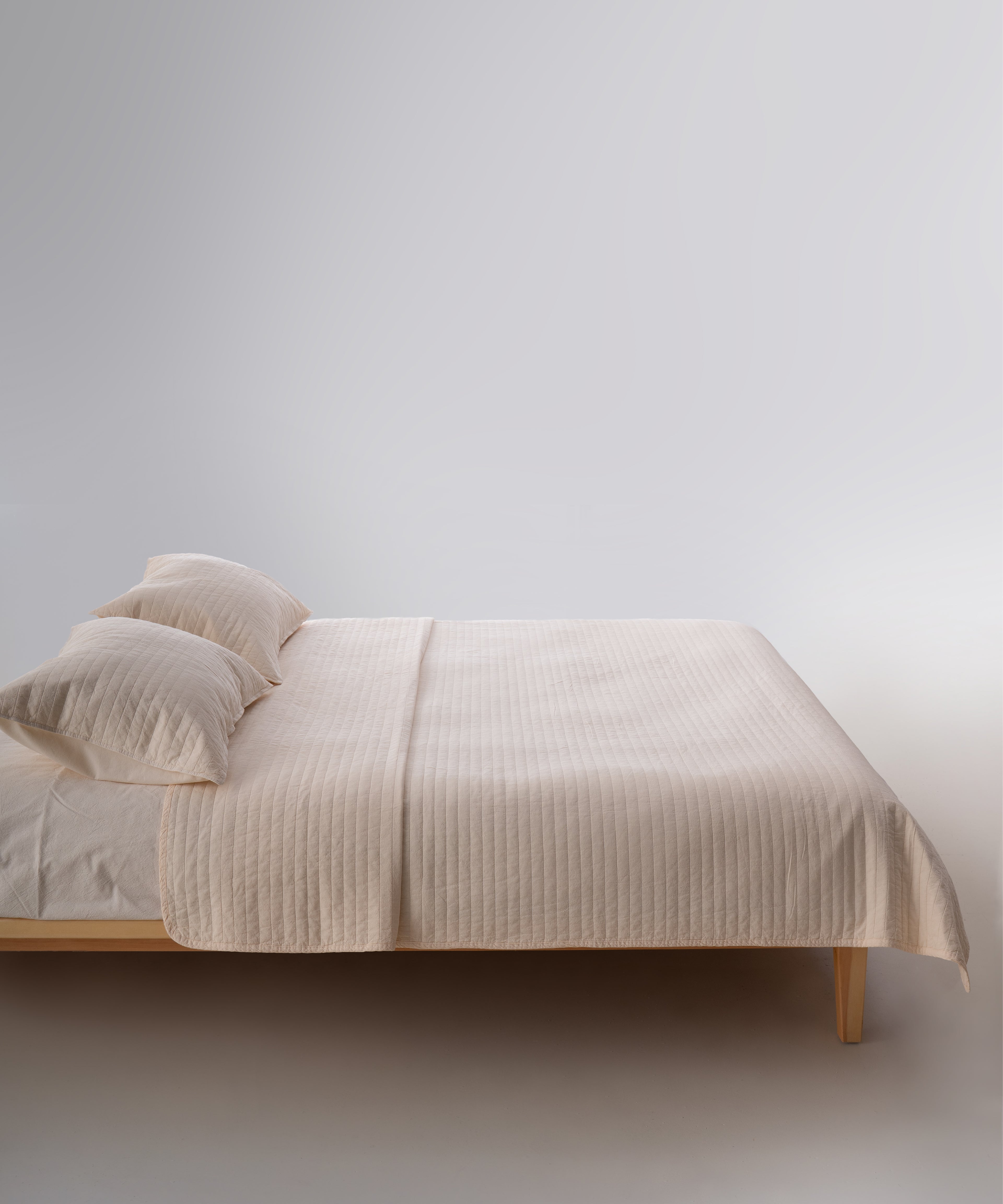 Cream renkli stonewash %100 pamuk yatak örtüsü kumaşının yumuşak ve doğal dokusu, yakın plan