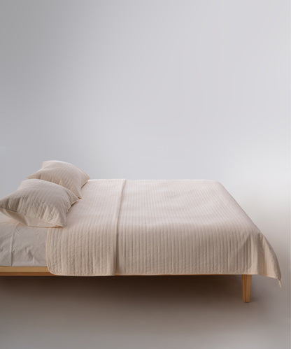 Cream renkli stonewash %100 pamuk yatak örtüsü kumaşının yumuşak ve doğal dokusu, yakın plan