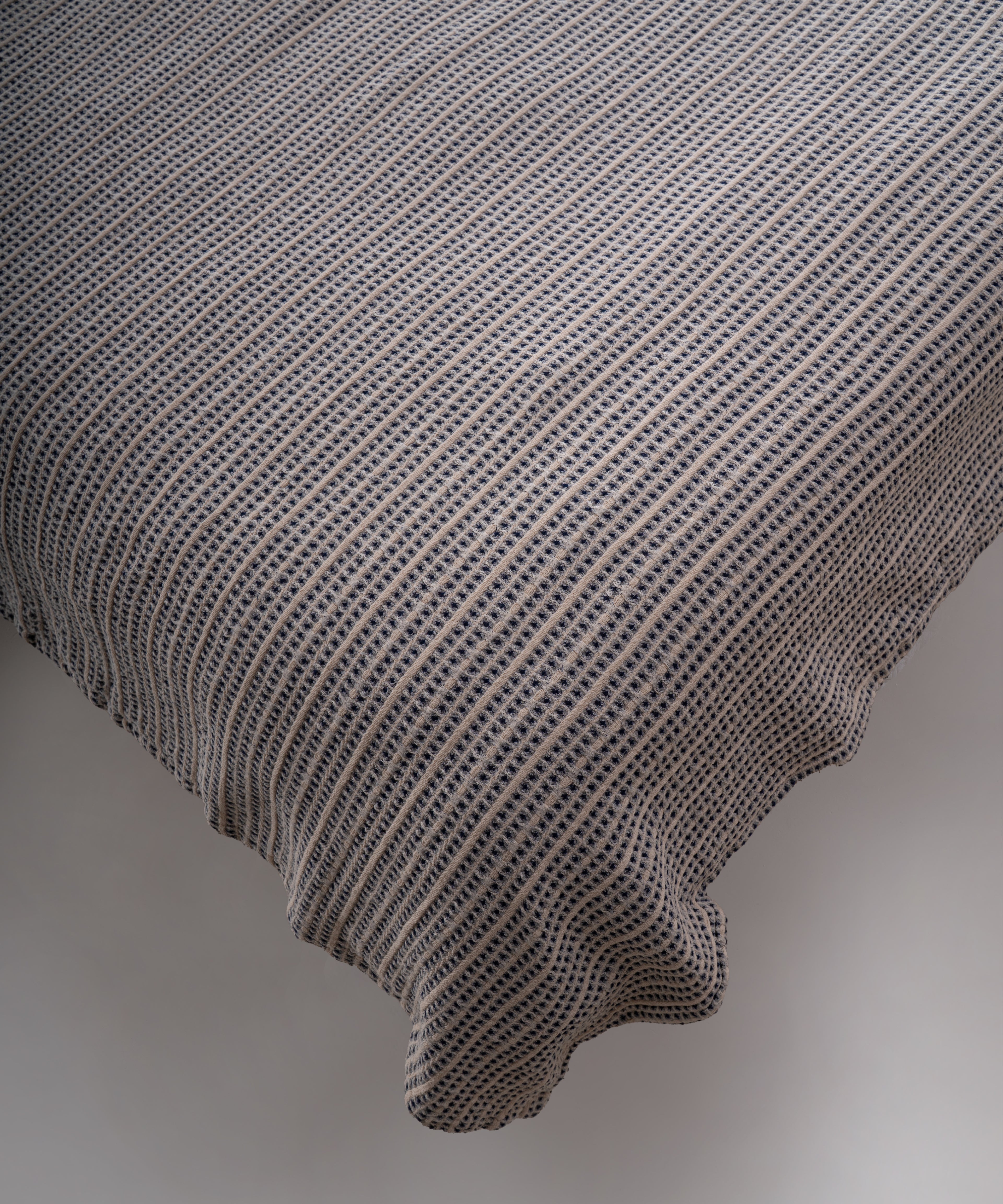 Indigo renkli stonewash %100 pamuk yatak örtüsü kumaşının yumuşak ve doğal dokusu, yakın plan