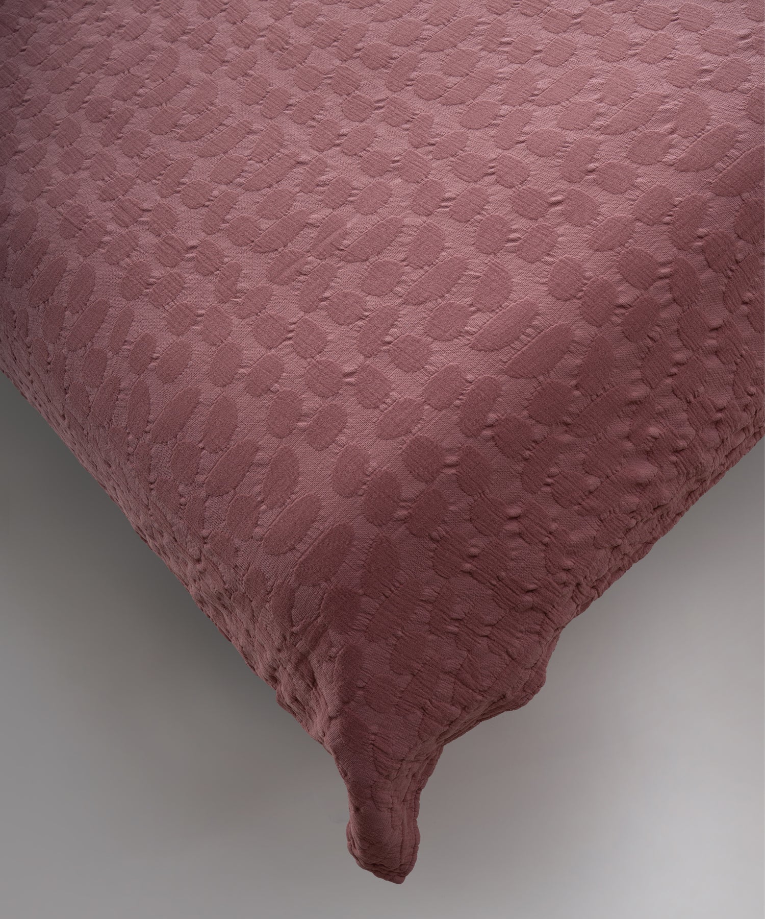 Old Rose renkli stonewash %100 pamuk yatak örtüsü kumaşının yumuşak ve doğal dokusu, yakın plan