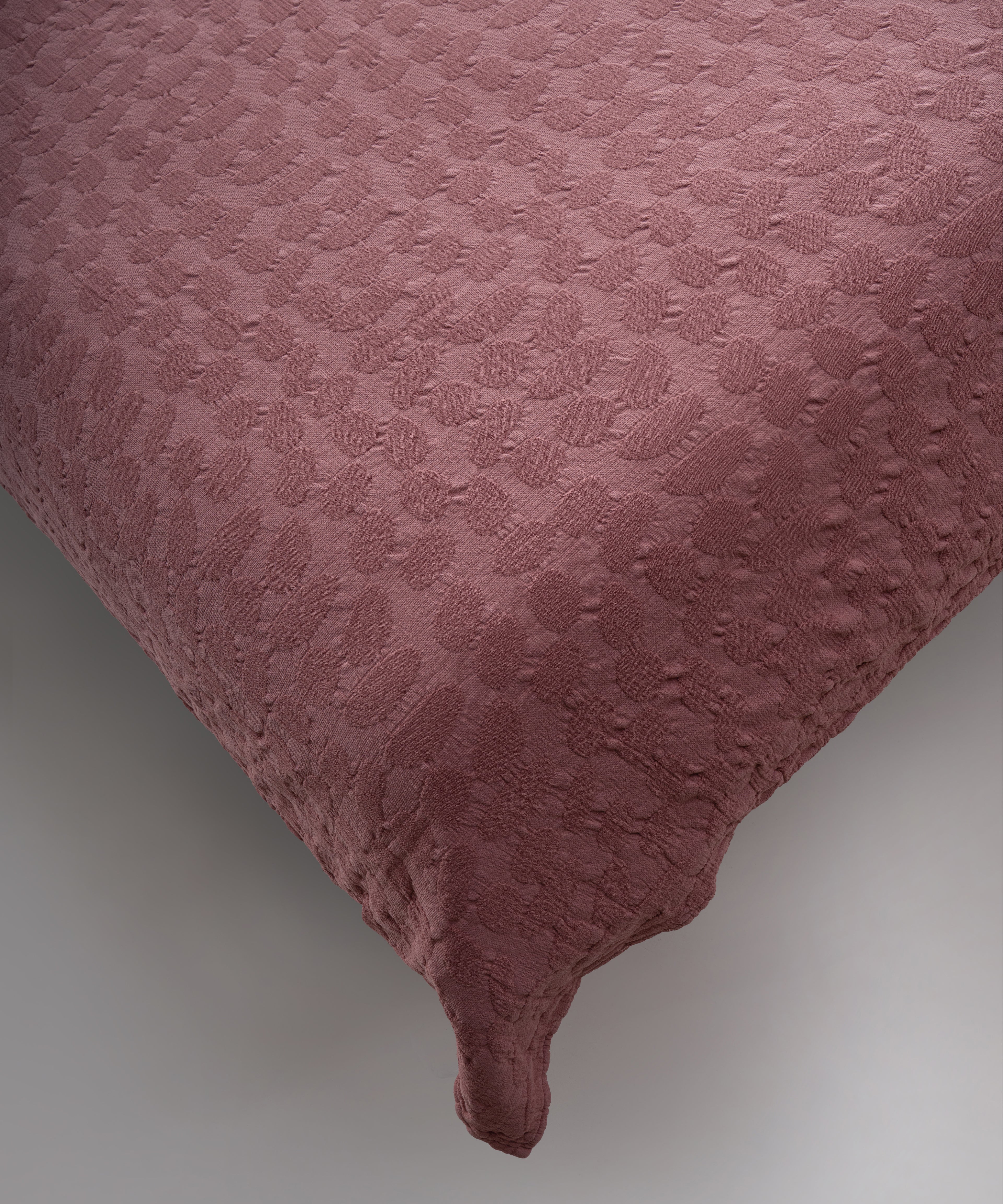 Old Rose renkli stonewash %100 pamuk yatak örtüsü kumaşının yumuşak ve doğal dokusu, yakın plan