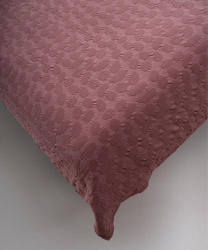 Old Rose renkli stonewash %100 pamuk yatak örtüsü kumaşının yumuşak ve doğal dokusu, yakın plan