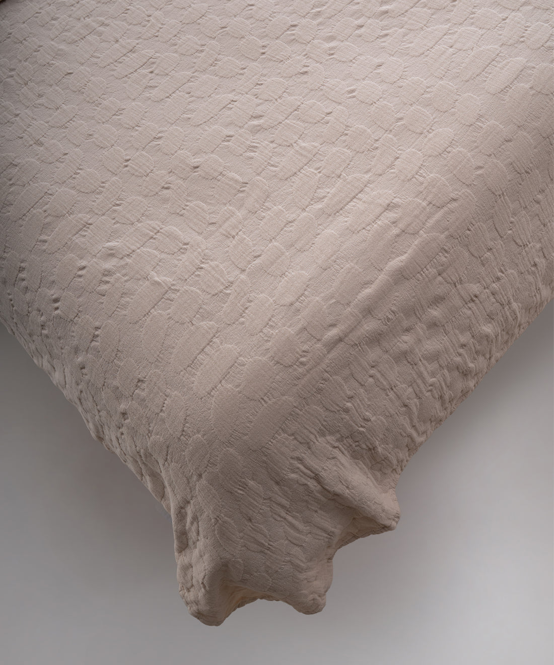 Cream renkli stonewash %100 pamuk yatak örtüsü kumaşının yumuşak ve doğal dokusu, yakın plan