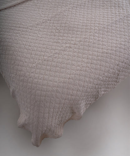 Cream renkli stonewash %100 pamuk yatak örtüsü kumaşının yumuşak ve doğal dokusu, yakın plan