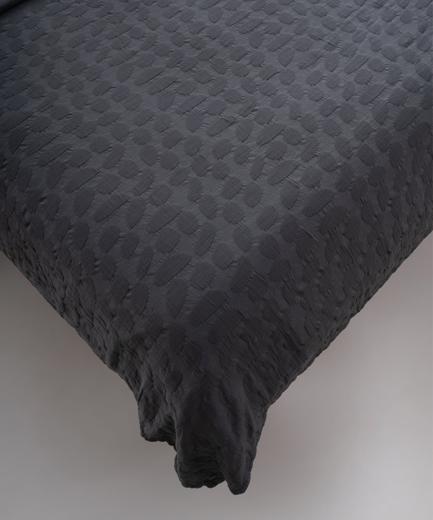 Castle Rock renkli stonewash %100 pamuk yatak örtüsü kumaşının yumuşak ve doğal dokusu, yakın plan