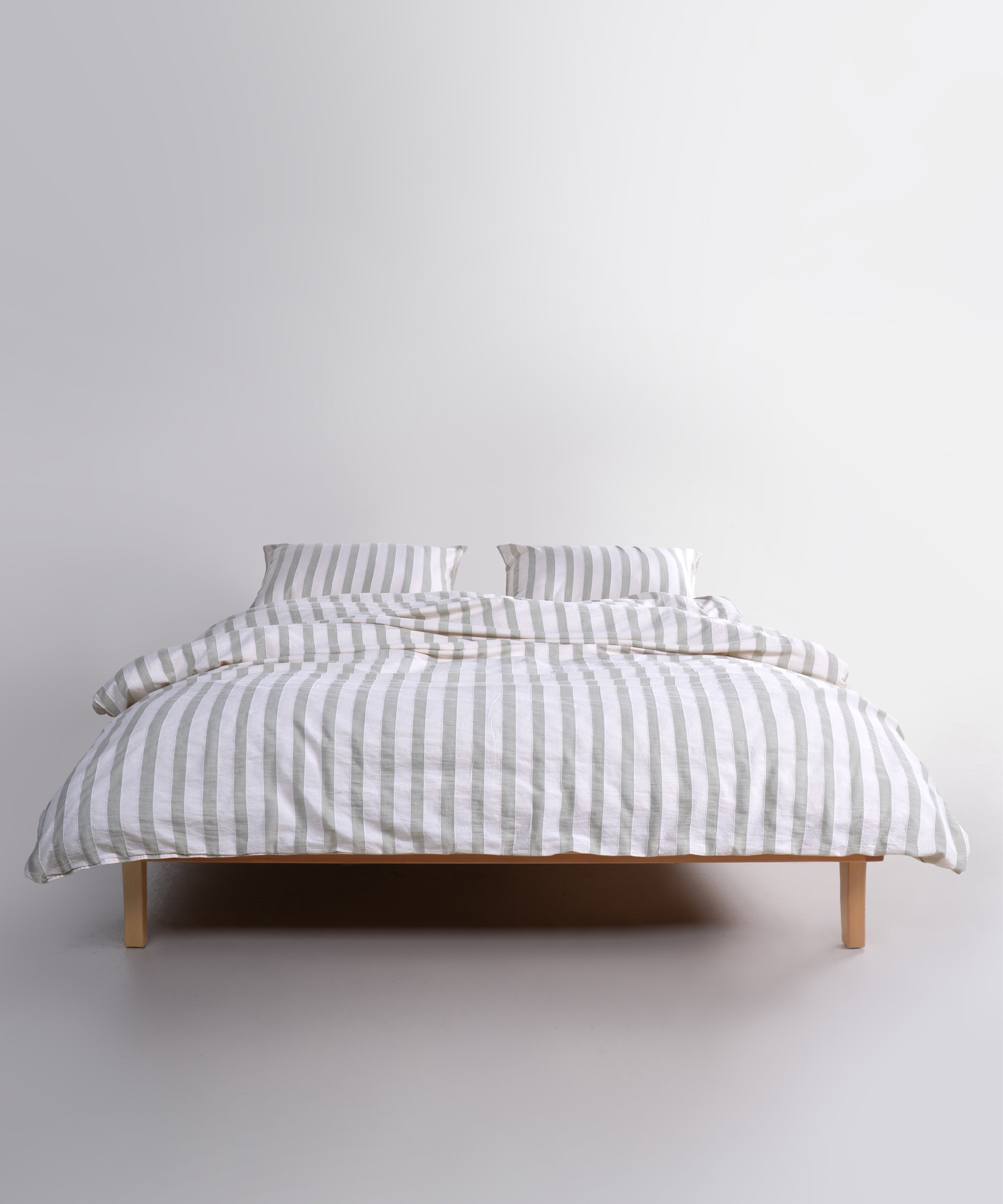 Doğadan ilham alan yeşil çizgili desen ve yumuşak pamuk kumaşıyla ferah yatak odası stili